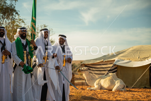 ارتداء زي العرضة النجدية الشعبية في المناسبة الوطنية، الاحتفال باليوم الوطني بالرقص بالسيوف وقرع الطبول، يوم بدينا ٢٢ فبراير، فرقة عروض الفلكلور التراثي في صحراء المملكة، جمل يجلس امام الخيمة، مفهوم حب الوطن والانتماء اليه، ذكرى تاسيس الدوله السعوديه الاولى ١٧٢٧ م