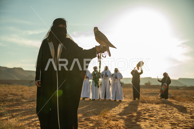 يوم بدينا 22 فبراير، مفهوم الافتراس وحدة البصر, مكانة الصقور في التاريخ السعودي, تربية الطائر الجارح, ذكرى تاسيس الدوله السعوديه الاولى 1727م, امرأة عربية خليجية سعودية ترتدي البشت النسائي السعودي و البرقع يقف على يدها الصقر, خلفية العرضة النجدية في الصحراء