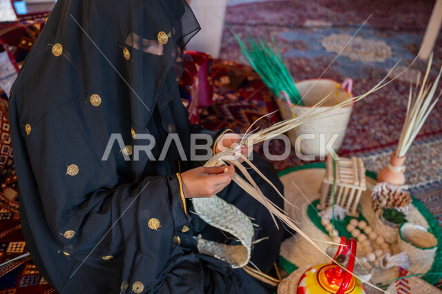 Popular handicraft, local national products, pride in the ancient Saudi heritage, the day we started February 22, close-up photo of a Saudi Gulf Arab woman wearing traditional folk costume making mats, anniversary of the founding of the first Saudi state 1727 AD
