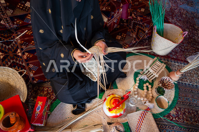 يوم بدينا 22 فبراير، الفخر بالتراث السعودي العريق، صورة مقربة امرأة عربية خليجية سعودية ترتدي الزي الشعبي التقليدي تقوم بصناعة الحصير، عرض المنتجات المحليه الوطنيه، حرفة يدوية شعبية، ذكرى تأسيس الدولة السعودية الأولى 1727 م