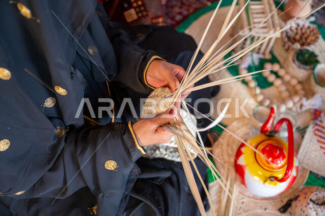 الفخر بالتراث السعودي العريق، يوم بدينا 22 فبراير، صورة مقربة امرأة عربية خليجية سعودية ترتدي الزي الشعبي التقليدي تقوم بصناعة الحصير، عرض المنتجات المحليه الوطنيه، حرفة يدوية شعبية، ذكرى تأسيس الدولة السعودية الأولى 1727 م