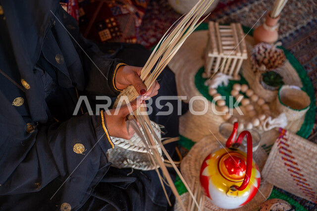 يوم بدينا 22 فبراير، الفخر بالتراث السعودي العريق، صورة مقربة امرأة عربية خليجية سعودية ترتدي الزي الشعبي التقليدي تقوم بصناعة الحصير، عرض المنتجات المحليه الوطنيه، حرفة يدوية شعبية، ذكرى تأسيس الدولة السعودية الأولى 1727 م