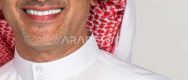 بورتريه لرجل عربي سعودي خليجي يبتسم ويظهر ثقة بالنفس , العناية بالأسنان وصحة اللثة , الإبتسامة المثالية , مفهوم صحة الأسنان , تبييض الأسنان , خلفية بيضاء .