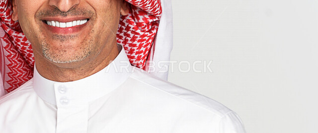 بورتريه لرجل عربي سعودي خليجي يبتسم ويظهر ثقة بالنفس , العناية بالأسنان وصحة اللثة , الإبتسامة المثالية , مفهوم صحة الأسنان , تبييض الأسنان , خلفية بيضاء .