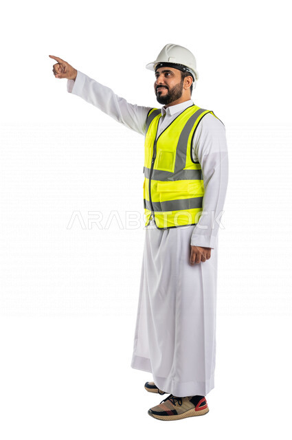 بورتريه لمهندس عربي خليجي سعودي يرتدي الخوذة والسترة الخاصة بالعمل ،يشير باصبع السبابة لهدف ما، الاشارة لموقع وبناء ، تحريك عنصر هولوجرامي ،خلفية بيضاء