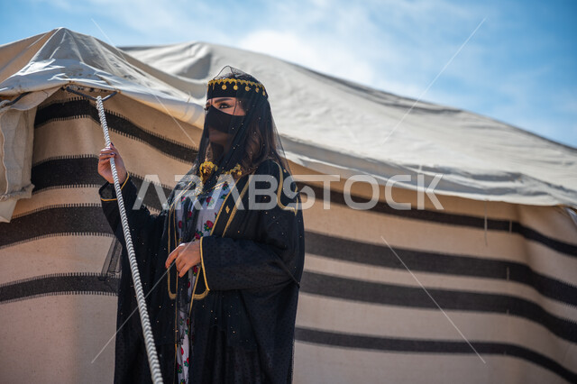 يوم بدينا  22 فبراير، ذكرى تأسيس الدولة السعودية الأولى في 1727م، الشموخ والاعتزاز والفخر، امرأة عربية خليجية سعودية ترتدي العباءة والبرقع تقف بجوار الخيمة في الصحراء, إظهار حب الوطن والانتماء إليه، ارتداء الزي الشعبي في المناسبة الوطنية