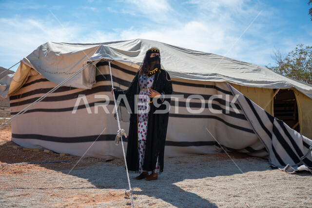 ذكرى تأسيس الدولة السعودية الأولى في 1727م، الشموخ والاعتزاز والفخر، امرأة عربية خليجية سعودية ترتدي العباءة والبرقع تقف بجوار الخيمة في الصحراء, إظهار حب الوطن والانتماء إليه، يوم بدينا  22 فبراير، ارتداء الزي الشعبي في المناسبة الوطنية