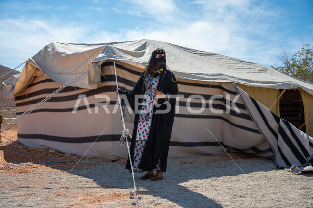 يوم بدينا  22 فبراير، ذكرى تأسيس الدولة السعودية الأولى في 1727م، الشموخ والاعتزاز والفخر، امرأة عربية خليجية سعودية ترتدي العباءة والبرقع تقف بجوار الخيمة في الصحراء, إظهار حب الوطن والانتماء إليه، ارتداء الزي الشعبي في المناسبة الوطنية