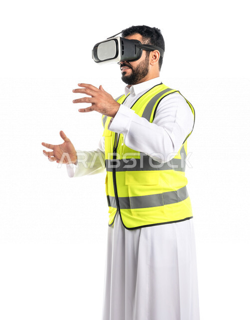 بورتريه لمهندس عربي خليجي سعودي يرتدي سترة خاصة بالعمل و نظارة الواقع الافتراضي ، يحمل شيء بين يديه ،تقدير حجم جسم معين ، استخدام تقنية الواقع الافتراضي في الهندسة المعمارية ، خلفية بيضاء