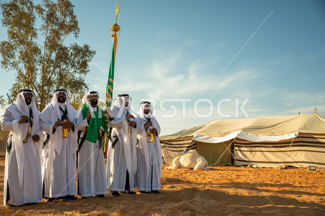 فرقة للاحتفال بالعيد الوطني بالرقص بالسيوف وقرع الطبول، ذكرى تأسيس الدوله السعوديه الأولى ١٧٢٧ م، عروض الفلكلور التراثي في إحدى المناطق الصحراوية بالمملكة، مفهوم حب الوطن والانتماء إليه، يوم بدينا ٢٢ فبراير، ارتداء زي العرضة النجدية الشعبية في مناسبة وطنية