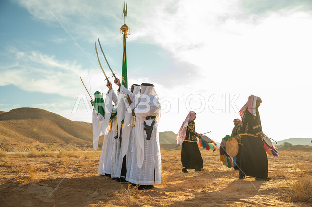 ارتداء زي العرضة النجدية الشعبية في مناسبة وطنية، فرقة عروض الفلكلور التراثي في احدى المناطق الصحراوية بالمملكة، مفهوم حب الوطن والانتماء إليه، يوم بدينا ٢٢ فبراير، ذكرى تأسيس الدوله السعوديه الأولى ١٧٢٧ م، الاحتفال بالعيد الوطني بالرقص بالسيوف وقرع الطبول 