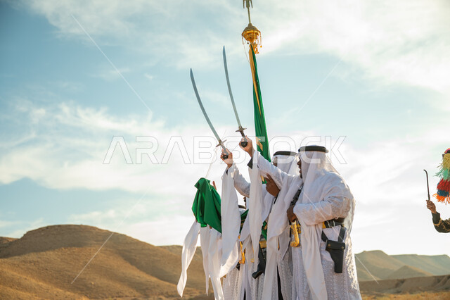 A band celebrating the National Day with sword dancing and drumming, the anniversary of the founding of the first Saudi state in 1727 AD, traditional folklore shows in one of the desert areas of the Kingdom, the concept of love of the homeland and belonging to it, the day we started on February 22, wearing the popular Najdi Ardah costume on a national occasion