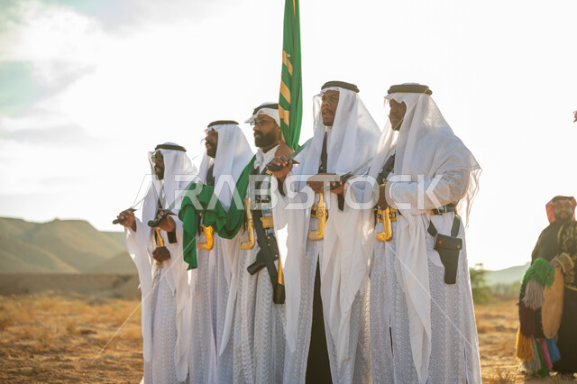 ارتداء زي العرضة النجدية الشعبية في مناسبة وطنية، فرقة عروض الفلكلور التراثي في احدى المناطق الصحراوية بالمملكة، مفهوم حب الوطن والانتماء إليه، يوم بدينا ٢٢ فبراير، ذكرى تأسيس الدوله السعوديه الأولى ١٧٢٧ م، الاحتفال بالعيد الوطني بالرقص بالسيوف وقرع الطبول 