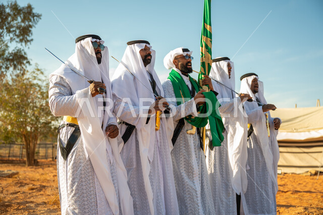 ذكرى تأسيس الدوله السعوديه الأولى ١٧٢٧ م، عروض الفلكلور التراثي في إحدى المناطق الصحراوية بالمملكة، مفهوم حب الوطن والانتماء إليه، فرقة للاحتفال بالعيد الوطني بالرقص بالسيوف وقرع الطبول، يوم بدينا ٢٢ فبراير، ارتداء زي العرضة النجدية الشعبية في مناسبة وطنية