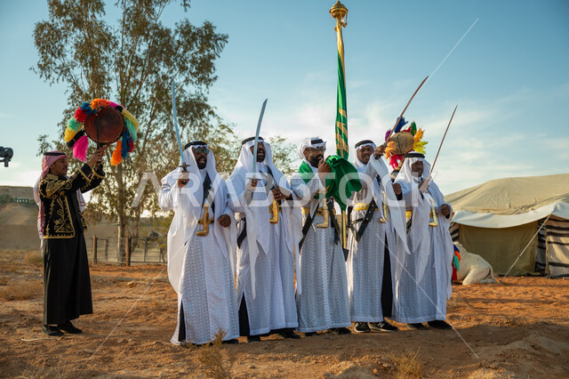 الاحتفال بالعيد الوطني بالرقص بالسيوف وقرع الطبول، يوم بدينا ٢٢ فبراير، فرقة عروض الفلكلور التراثي في احدى المناطق الصحراوية بالمملكة، ارتداء زي العرضة النجدية الشعبية في مناسبة وطنية، مفهوم حب الوطن والانتماء إليه، ذكرى تأسيس الدوله السعوديه الأولى ١٧٢٧ م