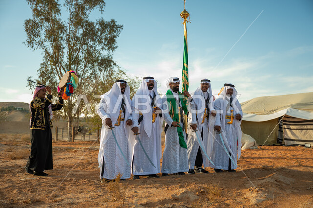 الاحتفال بالعيد الوطني بالرقص بالسيوف وقرع الطبول، يوم بدينا ٢٢ فبراير، فرقة عروض الفلكلور التراثي في احدى المناطق الصحراوية بالمملكة، ارتداء زي العرضة النجدية الشعبية في مناسبة وطنية، مفهوم حب الوطن والانتماء إليه، ذكرى تأسيس الدوله السعوديه الأولى ١٧٢٧ م