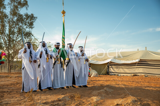 الاحتفال بالعيد الوطني بالرقص بالسيوف وقرع الطبول، يوم بدينا ٢٢ فبراير، فرقة عروض الفلكلور التراثي في احدى المناطق الصحراوية بالمملكة، ارتداء زي العرضة النجدية الشعبية في مناسبة وطنية، مفهوم حب الوطن والانتماء إليه، ذكرى تأسيس الدوله السعوديه الأولى ١٧٢٧ م