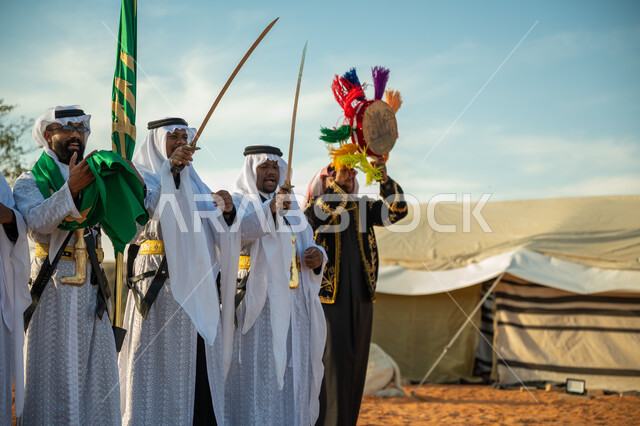 فرقة عروض الفلكلور التراثي في احدى المناطق الصحراوية بالمملكة، ارتداء زي العرضة النجدية الشعبية في مناسبة وطنية، مفهوم حب الوطن والانتماء إليه، يوم بدينا ٢٢ فبراير، ذكرى تأسيس الدوله السعوديه الأولى ١٧٢٧ م، الاحتفال بالعيد الوطني بالرقص بالسيوف وقرع الطبول 