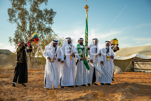 Wearing the Najdi Ardah costume on a national occasion, a folklore performance troupe in one of the desert regions of the Kingdom, the concept of love of the homeland and belonging to it, the day we started, February 22, the anniversary of the founding of the first Saudi state in 1727 AD, celebrating the National Day by dancing with swords and beating drums