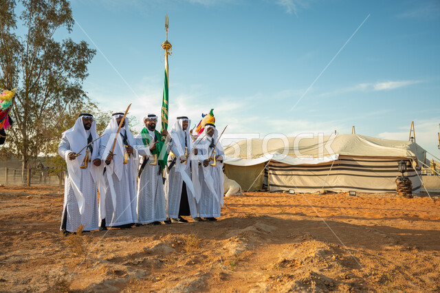ارتداء زي العرضة النجدية الشعبية في مناسبة وطنية، فرقة عروض الفلكلور التراثي في احدى المناطق الصحراوية بالمملكة، مفهوم حب الوطن والانتماء إليه، يوم بدينا ٢٢ فبراير، ذكرى تأسيس الدوله السعوديه الأولى ١٧٢٧ م، الاحتفال بالعيد الوطني بالرقص بالسيوف وقرع الطبول 