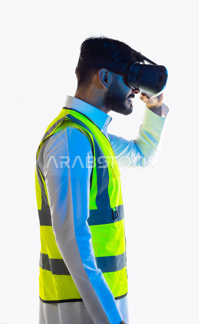 بورتريه لمهندس عربي خليجي سعودي يرتدي سترة خاصة بالعمل و نظارة الواقع الإفتراضي ثلاثية الأبعاد ، إدماج تقنية الواقع الافتراضي في الهندسة المعمارية ، تطبيق تكنولوجيا الواقع الافتراضي ، التخطيط الحَضَرِي ، خلفية بيضاء