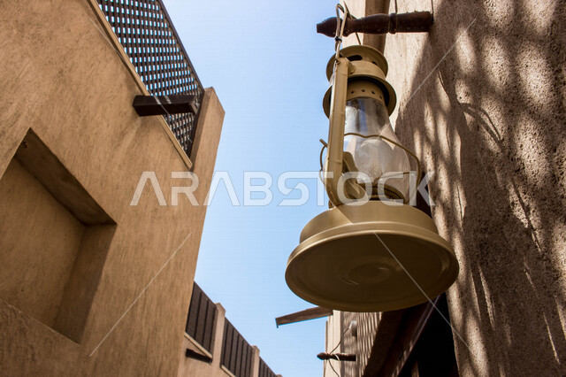 صورة لفانوس عربي تقليدي معلق على الجدار في منطقة الشندغة التاريخية في حي خور دبي في دولة الإمارات العربية المتحدة ، السياحة في الإمارات ، معالم أثرية سياحية شهيرة في الإمارات ، معالم تاريخية تراثية ، مصباح قديم الطراز مصنوعة من النحاس ، فانوس رمضان