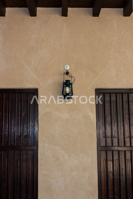 صورة لفانوس عربي تقليدي معلق على الجدار في منطقة الشندغة التاريخية في حي خور دبي في دولة الإمارات العربية المتحدة ، السياحة في الإمارات ، معالم أثرية سياحية شهيرة في الإمارات ، معالم تاريخية تراثية ، مصباح قديم الطراز مصنوعة من النحاس ، فانوس رمضان