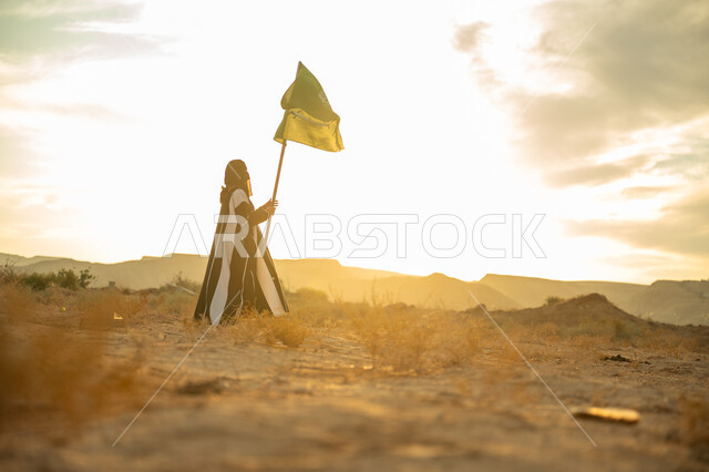 The day we started is February 22, the anniversary of the founding of the first Saudi state in 1727 AD, wearing traditional folk costume on a national occasion, pride and honor in the national identity, a side view of a Saudi Arabian Gulf woman wearing a burqa and an abaya raising the flagpole of the Kingdom at sunrise in the desert nature