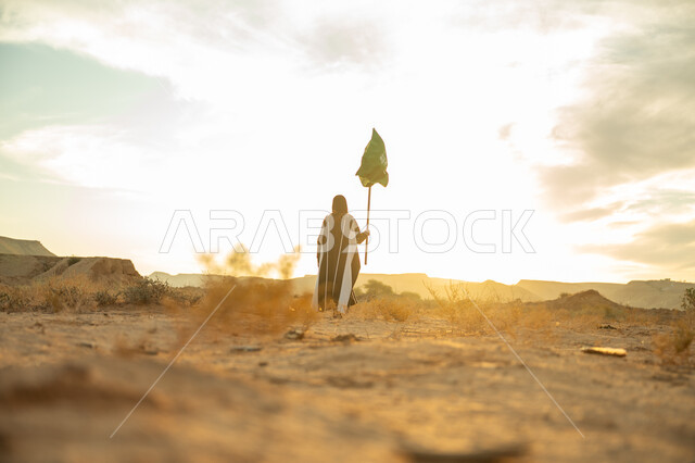 Pride and honor in national identity, the day we started February 22, the anniversary of the founding of the first Saudi state 1727 AD, wearing traditional folk costume on a national occasion, a picture from the back of a Saudi Arabian Gulf woman wearing a burqa and an abaya raising the flagpole of the Kingdom at sunrise in the desert nature