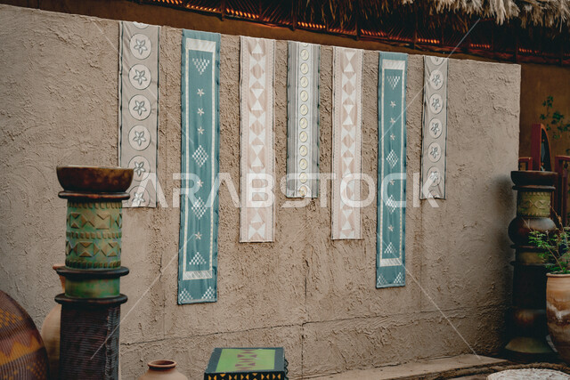 الأقمشة والمنسوجات الشعبية اليدوية المعلقة على حائط في متحف بالبلدة القديمة, المعالم السياحية الثقافية المشهورة في المملكة العربية السعودية, الاماكن التاريخية الأثرية التراثية, السياحة في مدينة العلا