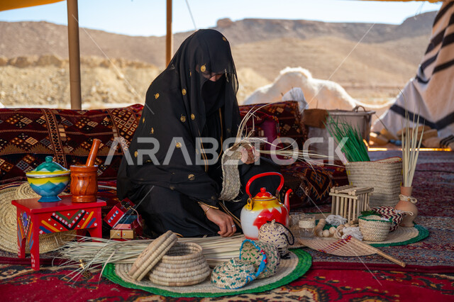 يوم بدينا 22 فبراير، ارتداء الزي الشعبي في المناسبة الوطنية، حرفة يدوية تقليدية, ذكرى تأسيس الدولة السعودية الأولى في 1727م، امرأة عربية خليجية سعودية ترتدي النقاب والعباءة تجلس في خيمة في الصحراء تقوم بجدل سعائف الخوص, استخدام أوراق النخيل المجففة في صناعة السلل
