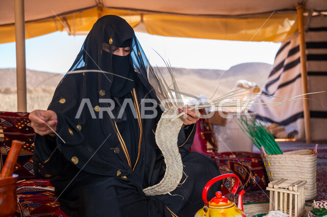 ارتداء الزي الشعبي في المناسبة الوطنية، حرفة يدوية تقليدية, ذكرى تأسيس الدولة السعودية الأولى في 1727م، امرأة عربية خليجية سعودية ترتدي النقاب والعباءة تجلس في خيمة في الصحراء تقوم بجدل سعائف الخوص, يوم بدينا 22 فبراير، استخدام أوراق النخيل المجففة في صناعة السلل