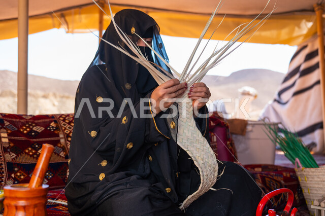 ارتداء الزي الشعبي في المناسبة الوطنية، حرفة يدوية تقليدية, ذكرى تأسيس الدولة السعودية الأولى في 1727م، امرأة عربية خليجية سعودية ترتدي النقاب والعباءة تجلس في خيمة في الصحراء تقوم بجدل سعائف الخوص, يوم بدينا 22 فبراير، استخدام أوراق النخيل المجففة في صناعة السلل