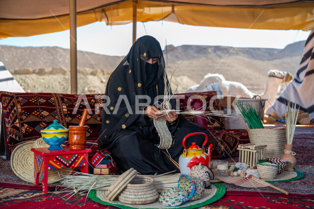 يوم بدينا 22 فبراير، ارتداء الزي الشعبي في المناسبة الوطنية، حرفة يدوية تقليدية, ذكرى تأسيس الدولة السعودية الأولى في 1727م، امرأة عربية خليجية سعودية ترتدي النقاب والعباءة تجلس في خيمة في الصحراء تقوم بجدل سعائف الخوص, استخدام أوراق النخيل المجففة في صناعة السلل