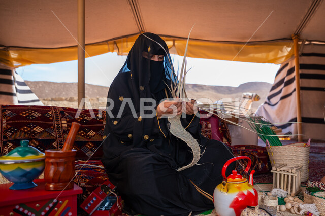 ارتداء الزي الشعبي في المناسبة الوطنية، حرفة يدوية تقليدية, ذكرى تأسيس الدولة السعودية الأولى في 1727م، امرأة عربية خليجية سعودية ترتدي النقاب والعباءة تجلس في خيمة في الصحراء تقوم بجدل سعائف الخوص, يوم بدينا 22 فبراير، استخدام أوراق النخيل المجففة في صناعة السلل