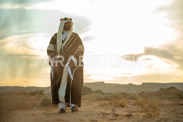 اظهار الولاء و التفاني للبلاد, ذكرى تاسيس الدوله السعوديه الاولى 1727 م, يوم بدينا 22 فبراير، رجل عربي خليجي سعودي يرتدي الغترة والبشت يتجول في الصحراء وينظر الى شيء ما, مفهوم حب الوطن و الانتماء اليه, مناسبة شعبيه وطنيه, خلفية الصحراء