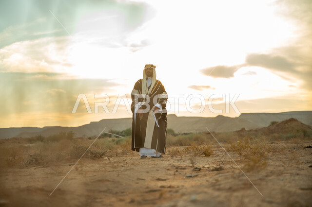 ذكرى تاسيس الدوله السعوديه الاولى 1727 م, يوم بدينا 22 فبراير, مفهوم حب الوطن و الانتماء اليه, مناسبة شعبيه وطنيه, اظهار الولاء و التفاني للبلاد, رجل عربي خليجي سعودي يرتدي الغترة والبشت يتجول في الصحراء وينظر الى شيء ما, خلفية الصحراء