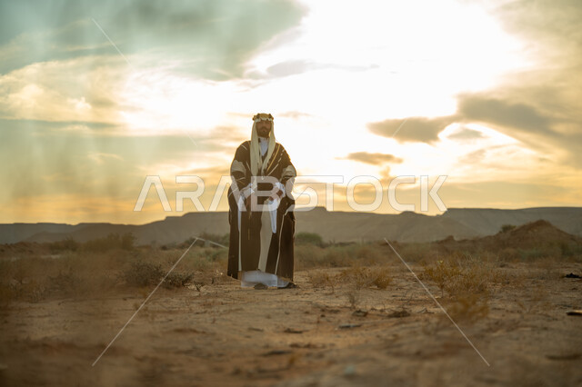 ذكرى تاسيس الدوله السعوديه الاولى 1727 م, يوم بدينا 22 فبراير, مفهوم حب الوطن و الانتماء اليه, مناسبة شعبيه وطنيه, اظهار الولاء و التفاني للبلاد, رجل عربي خليجي سعودي يرتدي الغترة والبشت يتجول في الصحراء وينظر الى شيء ما, خلفية الصحراء