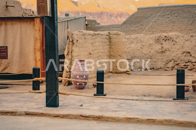 المباني التاريخية الأثرية, جرة مصنوعة من الفخار مركونة بجانب الجدار, الفن الهندسي المعماري على الطراز الطيني القديم, الأماكن السياحية التراثية المشهورة في المملكة العربية السعودية, البيوت الطينية الشعبية في البلدة القديمة, السياحة في مدينة العلا