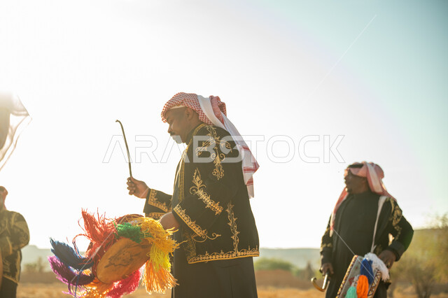فرقة رجال لعروض الفلكلور التراثي في احدى المناطق الصحراوية بالمملكة، ارتداء الزي الشعبي المطرز والشماغ في مناسبة وطنية، يوم بدينا ٢٢ فبراير، ذكرى تأسيس الدوله السعوديه الأولى ١٧٢٧ م، الاحتفال بالعيد الوطني بقرع الطبل المزين بخيوط ملونة، الأهازيج والرقص التقليدي