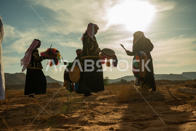 فرقة رجال لعروض الفلكلور التراثي في احدى المناطق الصحراوية بالمملكة، ارتداء الزي الشعبي المطرز والشماغ في مناسبة وطنية، يوم بدينا ٢٢ فبراير، ذكرى تأسيس الدوله السعوديه الأولى ١٧٢٧ م، الاحتفال بالعيد الوطني بقرع الطبل المزين بخيوط ملونة، الأهازيج والرقص التقليدي