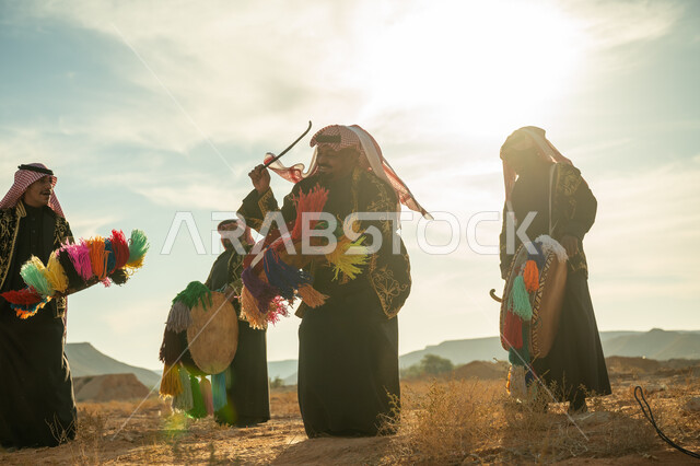 الأهازيج والرقص التقليدي، فرقة رجال لعروض الفلكلور التراثي في احدى المناطق الصحراوية بالمملكة، ارتداء الزي الشعبي المطرز والشماغ في مناسبة وطنية، يوم بدينا ٢٢ فبراير، ذكرى تأسيس الدوله السعوديه الأولى ١٧٢٧ م، الاحتفال بالعيد الوطني بقرع الطبل المزين بخيوط ملونة