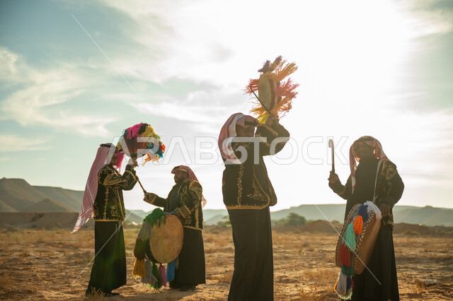 الأهازيج والرقص التقليدي، فرقة رجال لعروض الفلكلور التراثي في احدى المناطق الصحراوية بالمملكة، ارتداء الزي الشعبي المطرز والشماغ في مناسبة وطنية، يوم بدينا ٢٢ فبراير، ذكرى تأسيس الدوله السعوديه الأولى ١٧٢٧ م، الاحتفال بالعيد الوطني بقرع الطبل المزين بخيوط ملونة