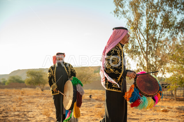 فرقة رجال لعروض الفلكلور التراثي في احدى المناطق الصحراوية بالمملكة، ارتداء الزي الشعبي المطرز والشماغ في مناسبة وطنية، يوم بدينا ٢٢ فبراير، ذكرى تأسيس الدوله السعوديه الأولى ١٧٢٧ م، الاحتفال بالعيد الوطني بقرع الطبل المزين بخيوط ملونة، الأهازيج والرقص التقليدي