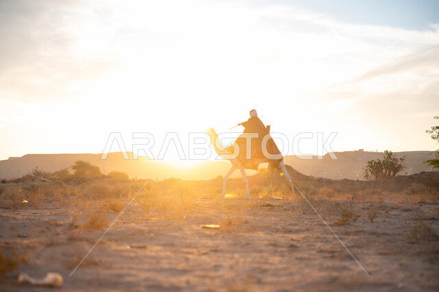 الاعتزاز والفخر بالانتماء للوطن, يوم بدينا 22 فبراير, ارتداء الزي الشعبي في المناسبة الوطنية, صورة من الجانب لرجل عربي خليجي سعودي يرتدي البشت التقليدي والغترة يمتطي الجمل وسط الصحراء في وقت غروب الشمس, ذكرى تأسيس الدولة السعودية الأولى 1727م
