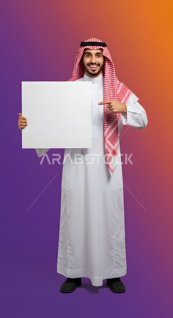 Advertisement and marketing presentation, using a whiteboard and educational tool, mockup of a white square, portrait of a smiling Saudi Arabian Gulf young man wearing a traditional thobe and shemagh pointing with his index finger at an empty white square board looking at the camera with gestures of pleasure, full body image, colored background