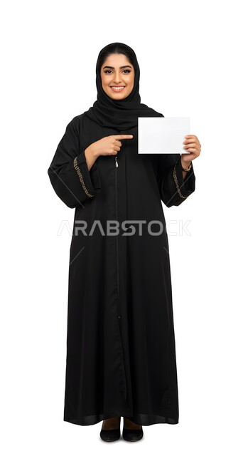 إعلان وعرض تسويقي، موك اب مربع أبيض، استخدام وسيلة توضيحية تعليمية، بورتريه لسيدة عربية خليجية سعودية مبتسمة محجبة ترتدي العباءة السوداء تشير بإصبع السبابة إلى لوحه بيضاء مربعه فارغة تنظر إلى الكاميرا بإيماءات السرور، صورة الجسم بالطول الكامل، خلفية بيضاء