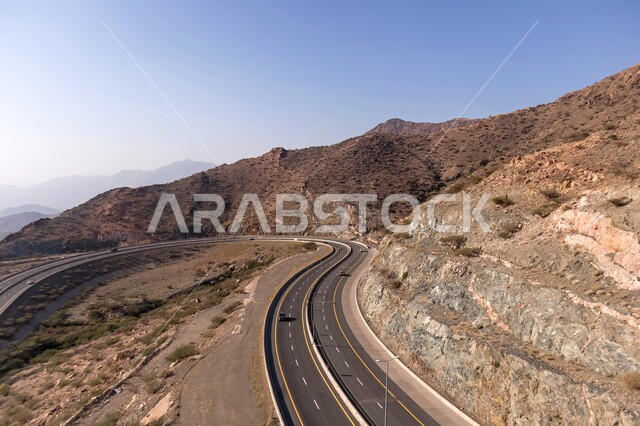 الطبيعة والبيئة الجبلية القاسية، القمم والمرتفعات في المملكة العربية السعودية، طريق إسفلتي ملتوي وعر وسط الجبال الصخرية، حركة مرور السيارات في مدينة الطائف، الطرق والشوارع المعبدة السريعة, الاهتمام بتهيئة البنية التحتية