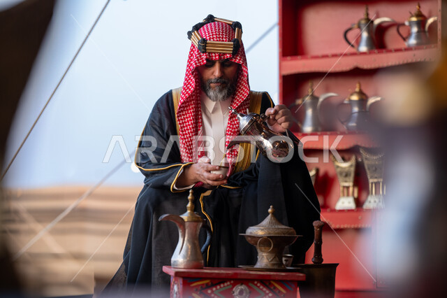 ذكرى تاسيس الدوله السعوديه الاولى 1727م, يوم بدينا 22 فبراير، رجل عربي خليجي سعودي يرتدي البشت و الشماغ التقليدي يقوم بصب القهوة في خيمة شعبية في الصحراء في النهار، مفهوم حسن الضيافة والاستقبال عند العرب، مناسبة و احتفال وطني