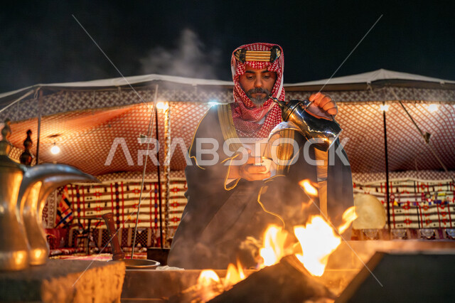 اجواء شتوية ليلية, يوم بدينا 22 فبراير، ذكرى تاسيس الدوله السعوديه الاولى 1727م, رجل عربي خليجي سعودي يرتدي البشت و الشماغ التقليدي يقوم بصب القهوة, خيمة شعبية في الصحراء، مفهوم حسن الضيافة والاستقبال عند العرب، مناسبة و احتفال وطني
